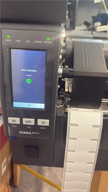 Zebra ZT411 — RFID Calibration Complete screen with green tick, RFID label media loaded and ready